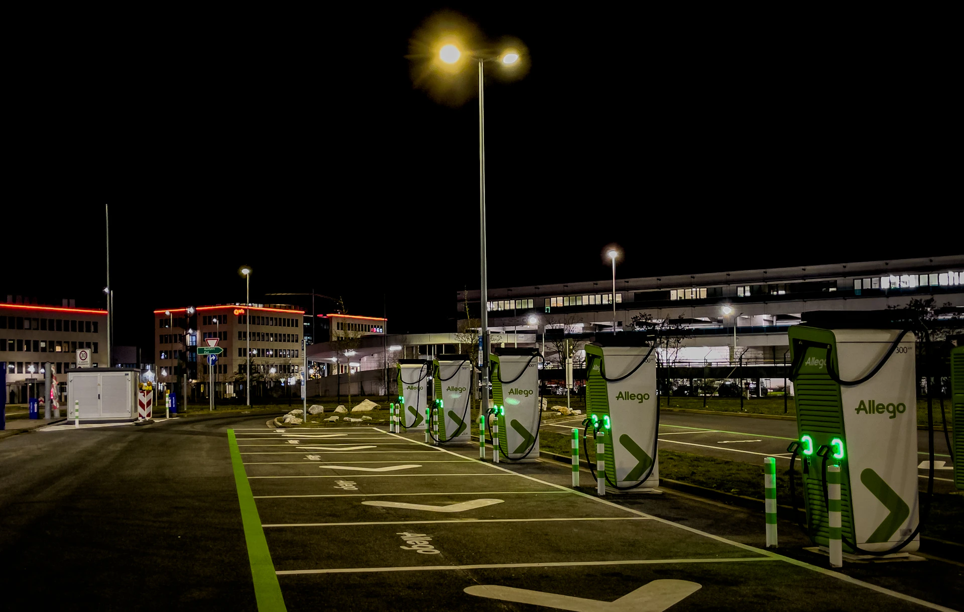 EV charging bays in a car park at night
