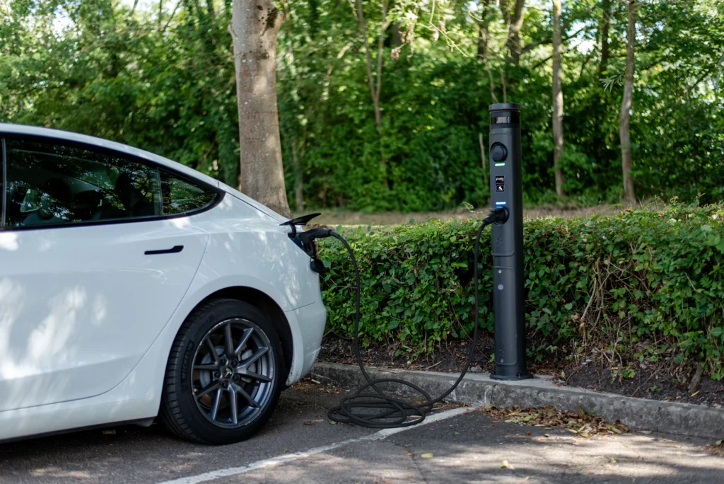 White electric car plugged in at a charging station