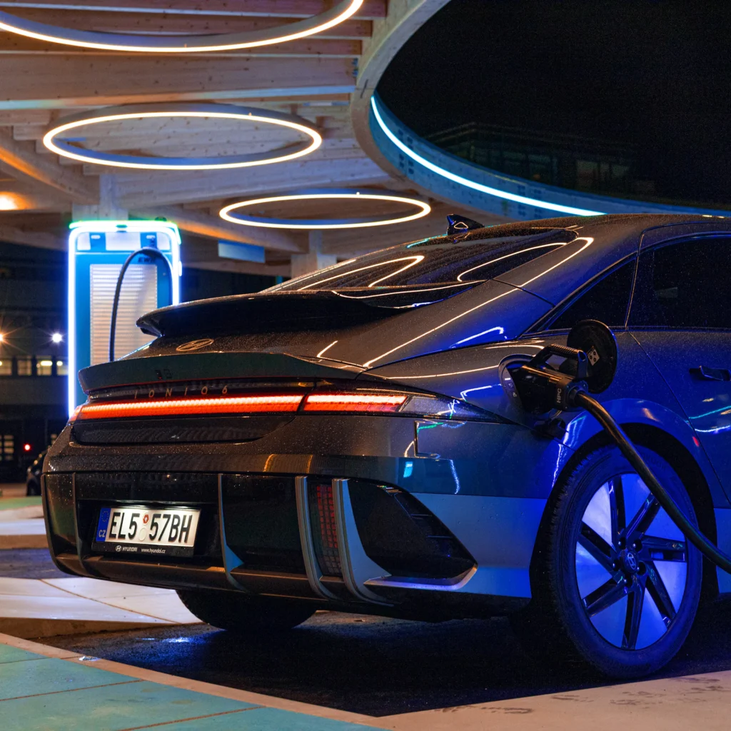 Electric car charging under blue lights at night